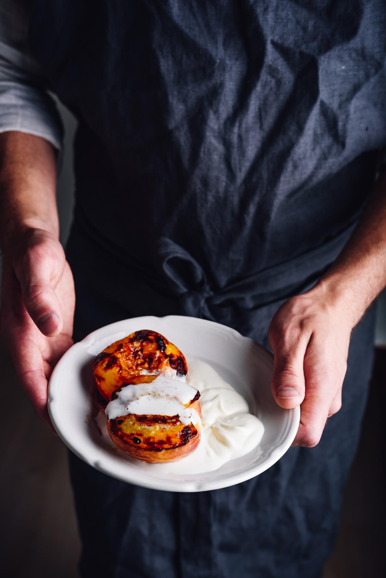 Chef arranging plated dish in calm studio